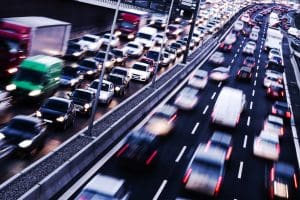 A blurred photograph of a traffic jam on a motorway featuring all types of vehicles